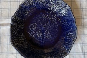 Blått större fat där spetsmönster som lyfter den vackra glasyren.