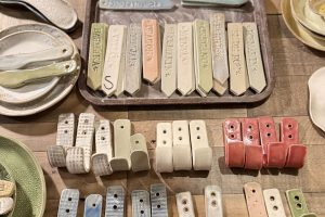 Handgjorda väggkrokar och planteringspinnar i en större modell.